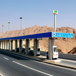**Image Prompt:** A well-maintained Omani highway with modern toll booths. Show vehicles passing through smoothly using an Electronic Toll Collection (ETC) system. The scenery should depict a clear, sunny day with the Omani landscape in the background. Focus on the efficiency and technological aspect of the ETC system.